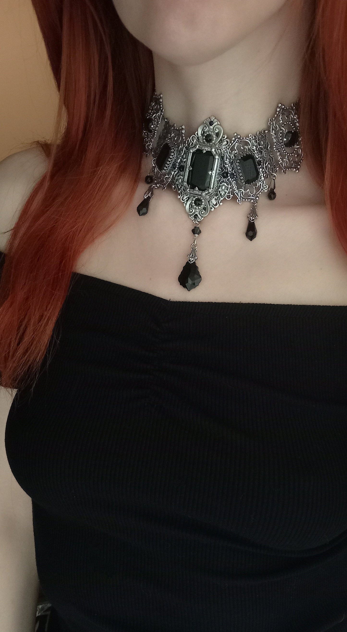 Luxurious vintage-inspired silver jewelry ensemble with detailed filigree and dazzling black crystal accents, radiating confidence and elegance.