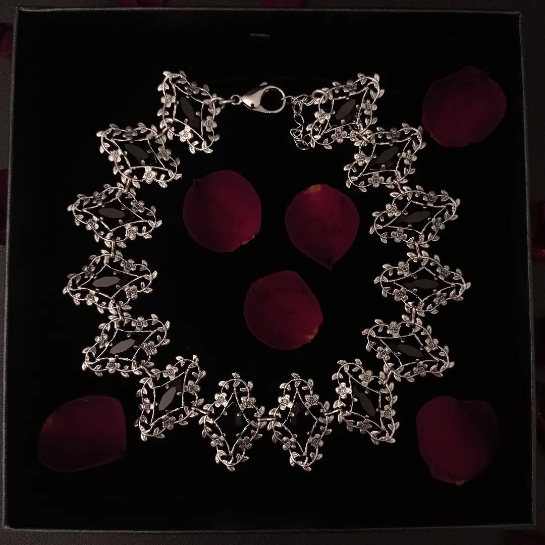 Exquisite silver jewelry artistry with delicate flower and leaves frames that showcase marquis shaped black crystals, radiating elegance and timeless allure.