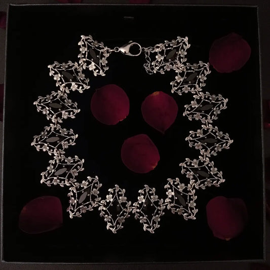 Exquisite silver jewelry artistry with delicate flower and leaves frames that showcase marquis shaped black crystals, radiating elegance and timeless allure.