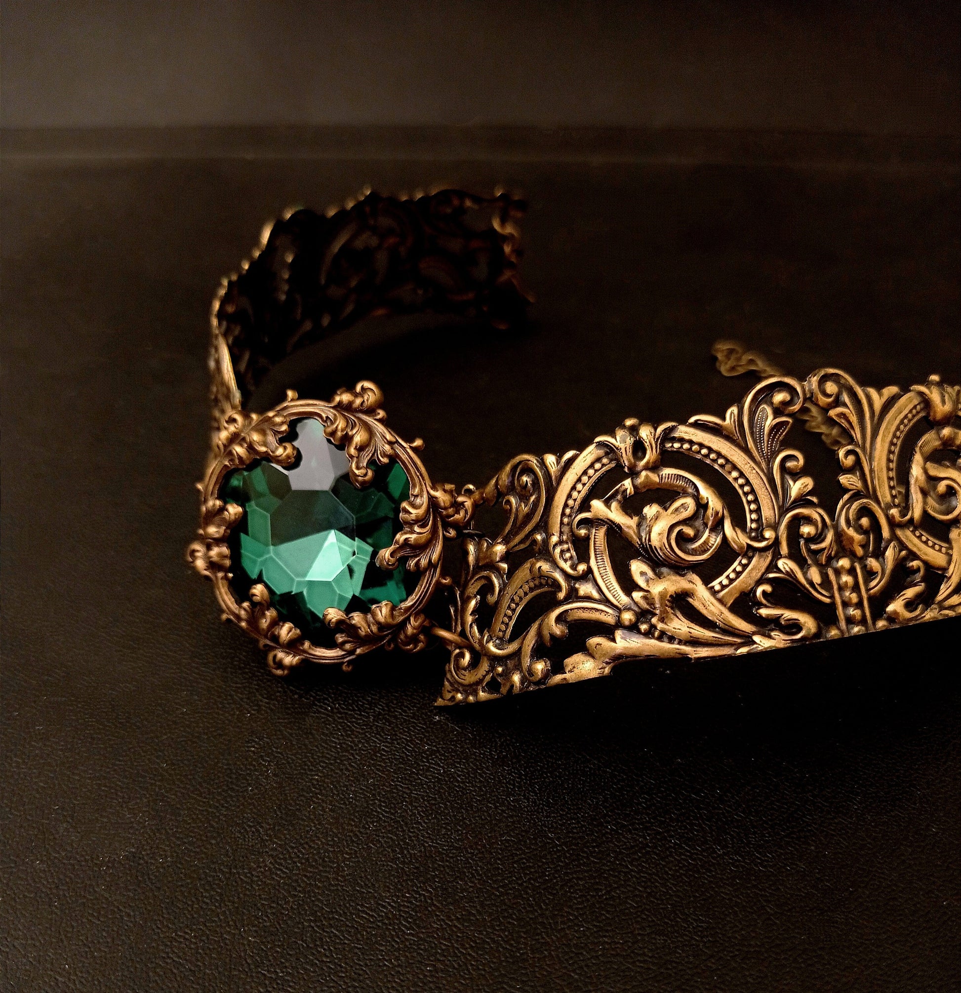Luxurious brass choker adorned with a vibrant green stone, showcasing exquisite craftsmanship and style.