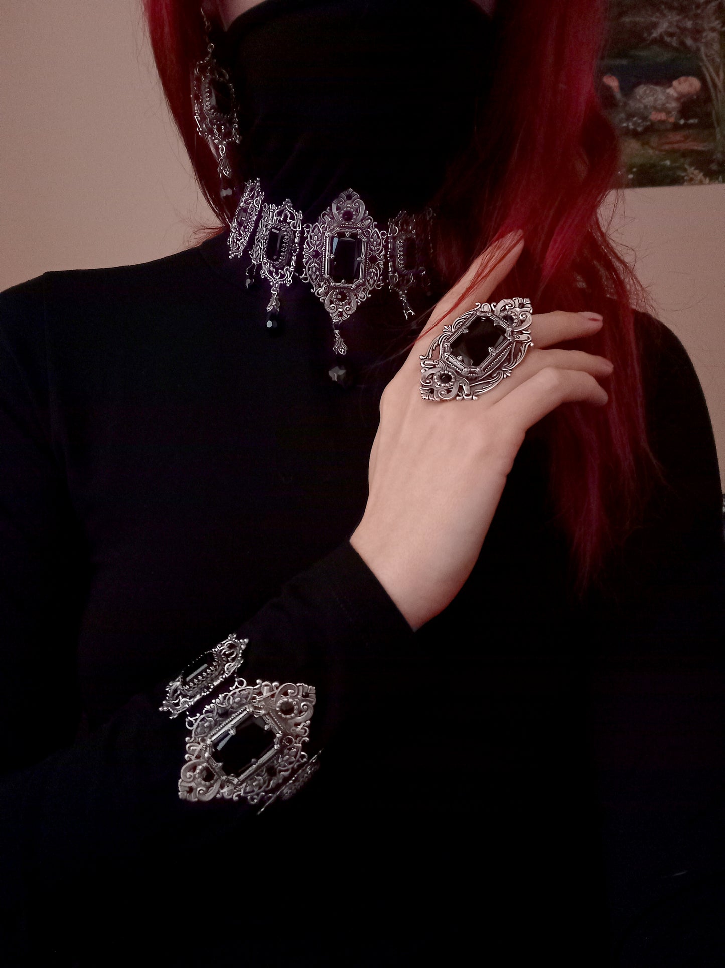 Luxurious vintage-inspired silver jewelry ensemble with detailed filigree and dazzling black crystal accents, radiating confidence and elegance.