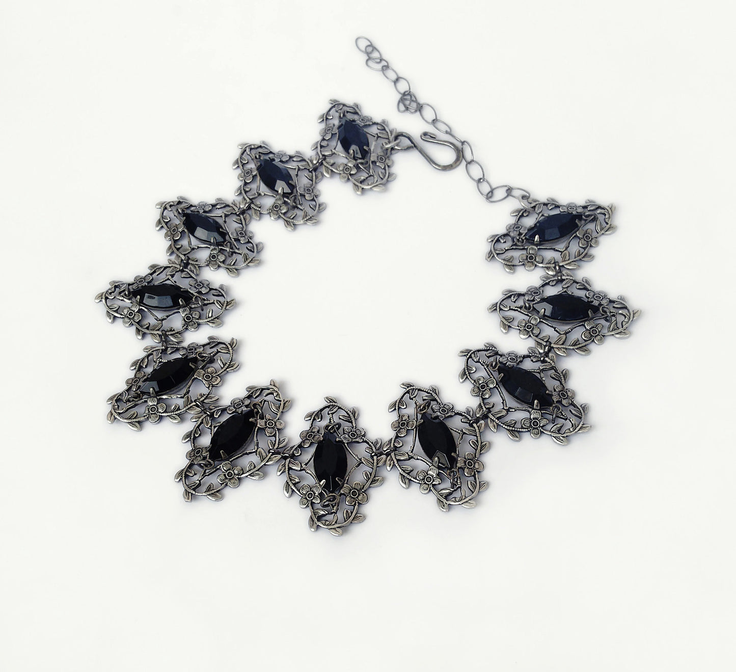 Exquisite silver jewelry artistry with delicate flower and leaves frames that showcase marquis shaped black crystals, radiating elegance and timeless allure.