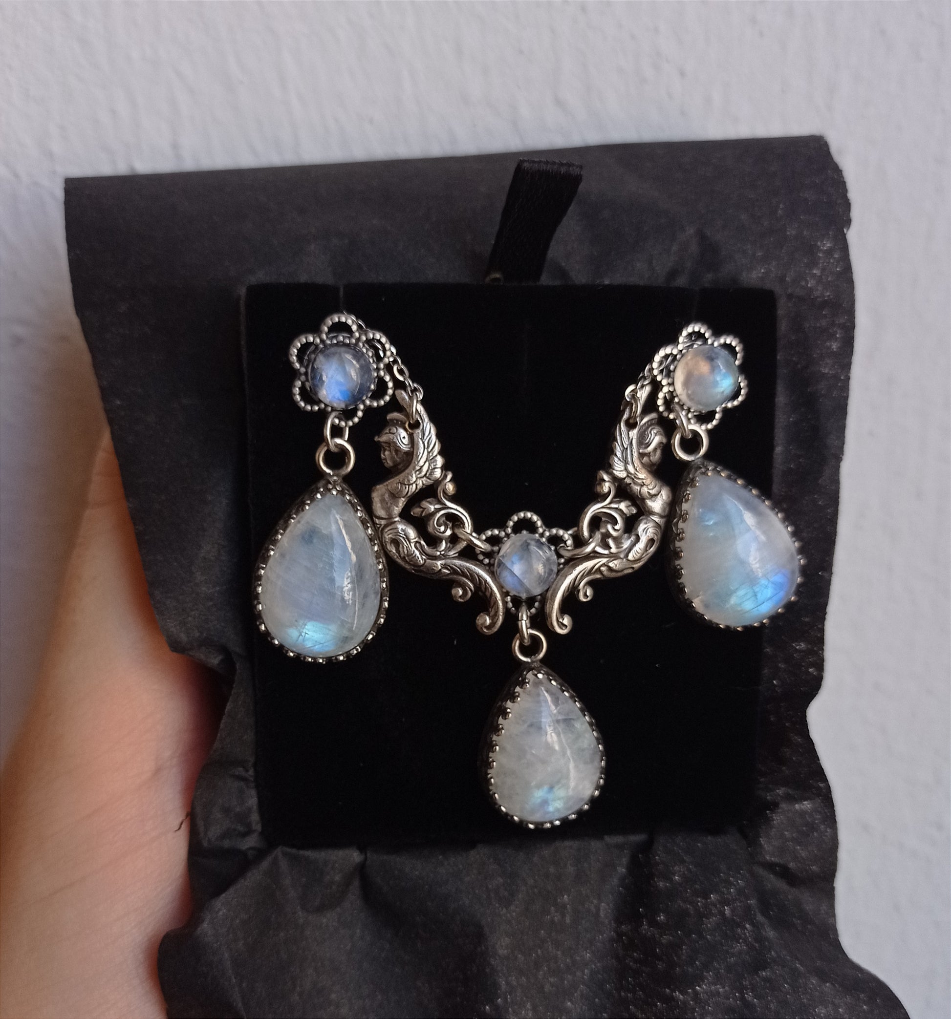 Delicate Victorian necklace featuring a beautiful center piece with two winged females supporting two gorgeous rainbow moonstone cabochons between them.