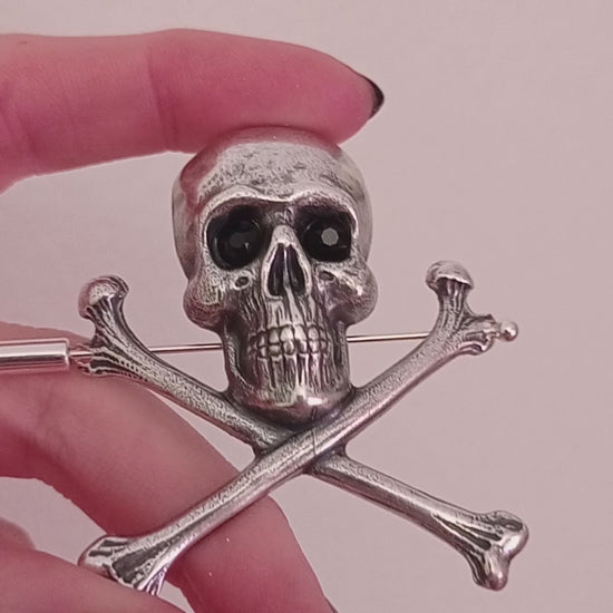 Large silver skull and crossbones brooch pin with crystal eyes.