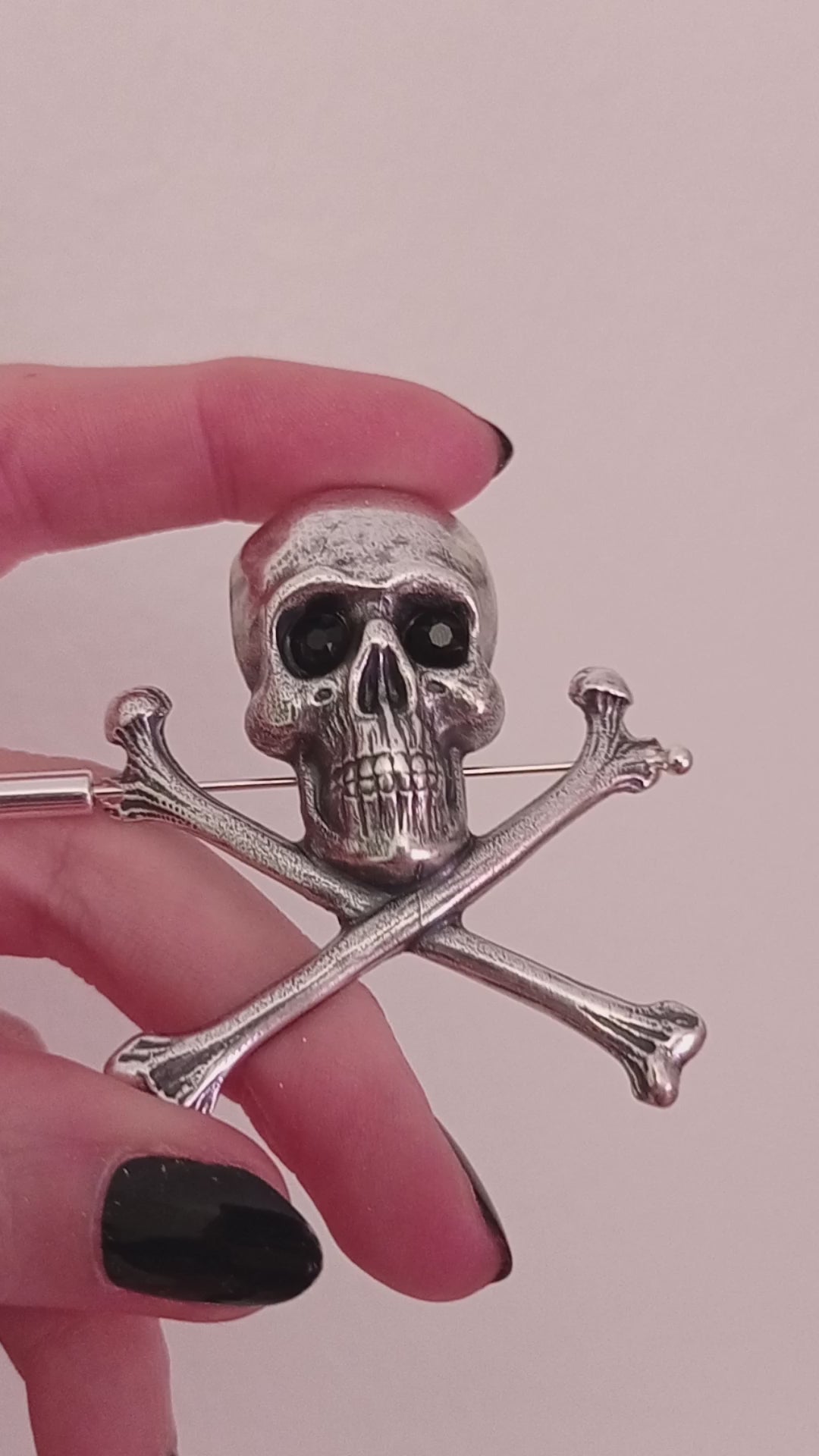 Large silver skull and crossbones brooch pin with crystal eyes.