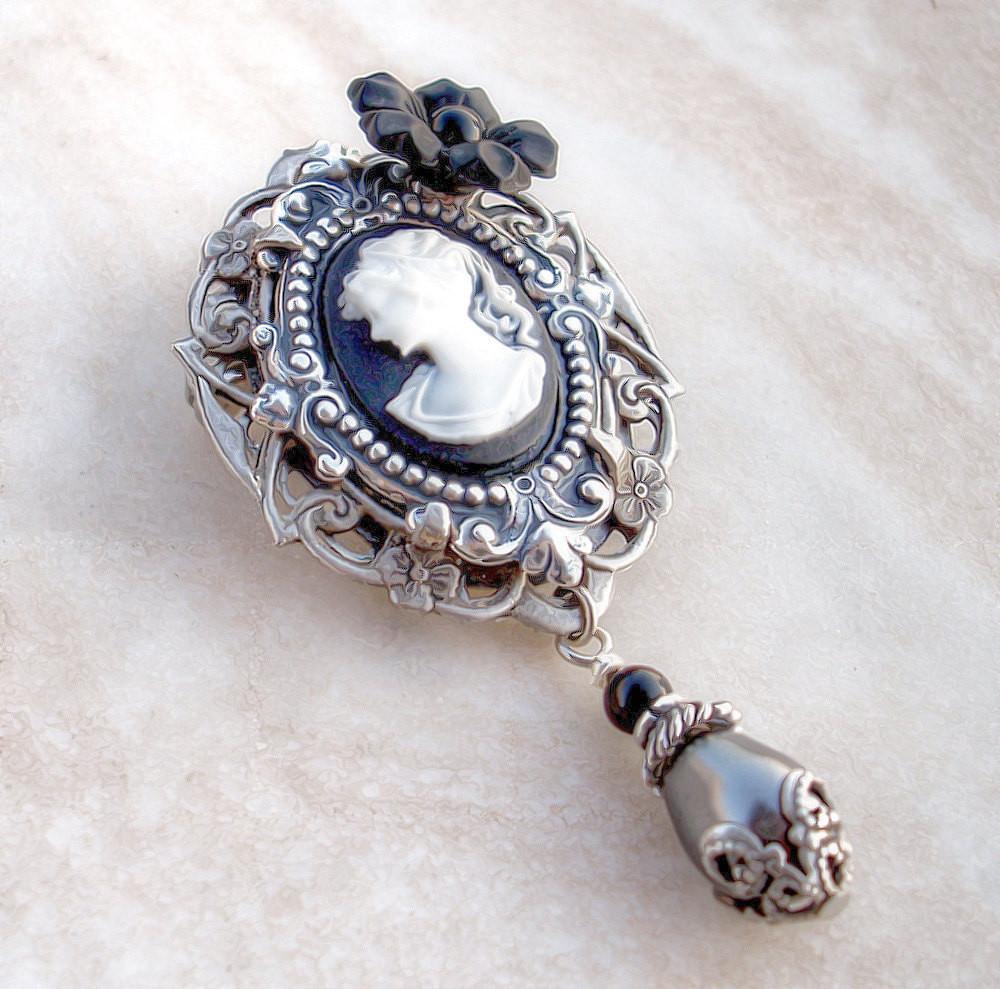 Add romance to your look with this victorian gothic brooch featuring ornate silver l settings, a white on black cameo of a lady's profile, a black flower and black pearls. Victorian Gothic jewelry by Aranwen.