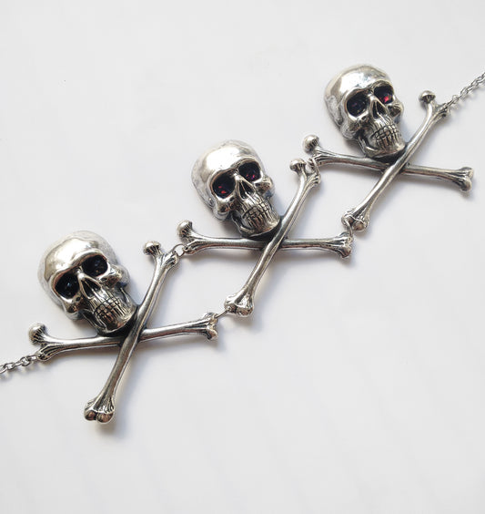 Add macabre flair to your look with this Large silver skulls and crossbones Gothic choker, with burgundy crystals set in their eyes! Nickel and lead free.