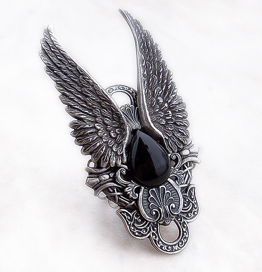 A unisex black onyx ring featuring intricate wing designs, symbolizing freedom and elegance.