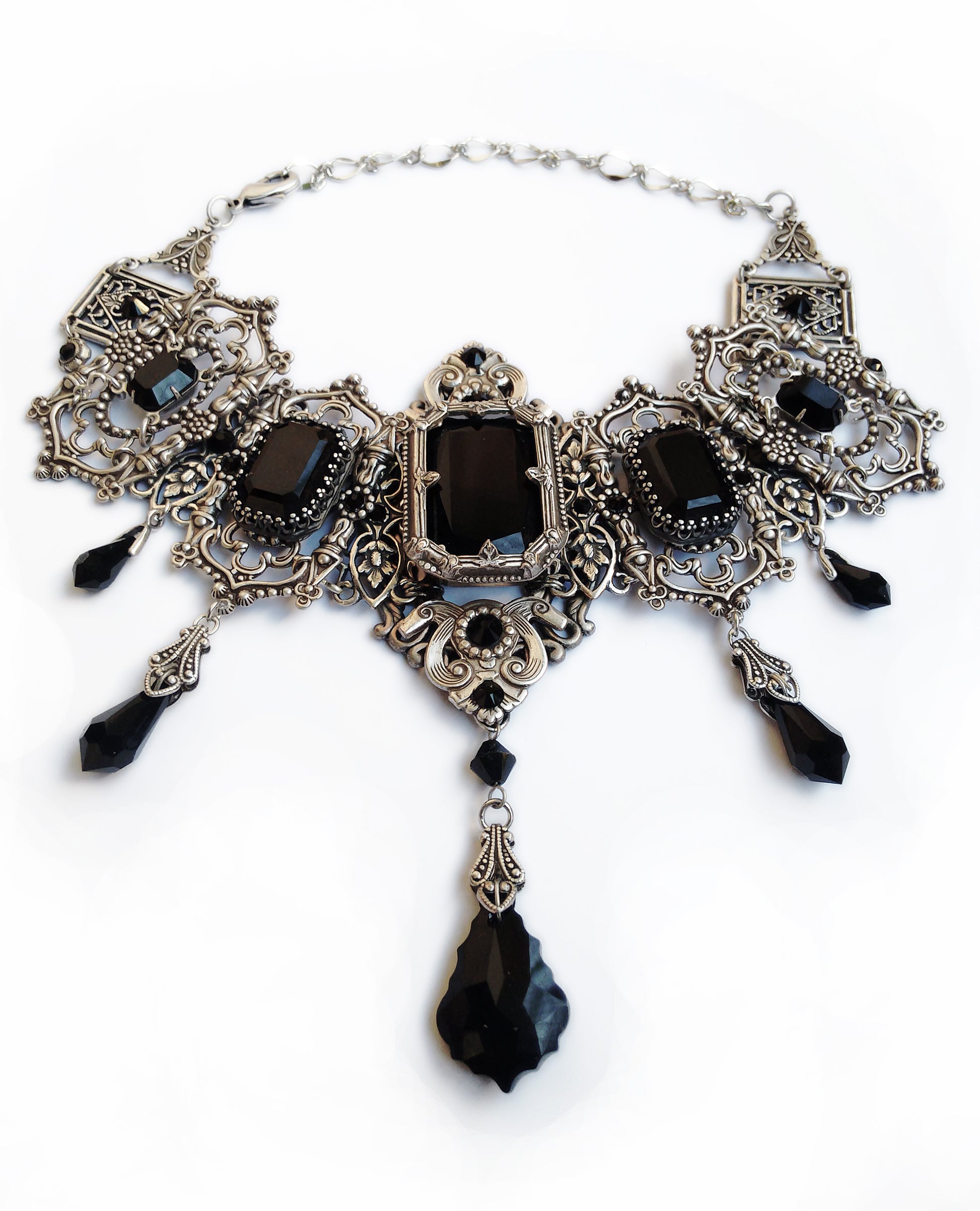 Most intricate silver choker necklace adorned with ornate black gemstones and teardrop charms, showcasing vintage elegance and gothic style.
