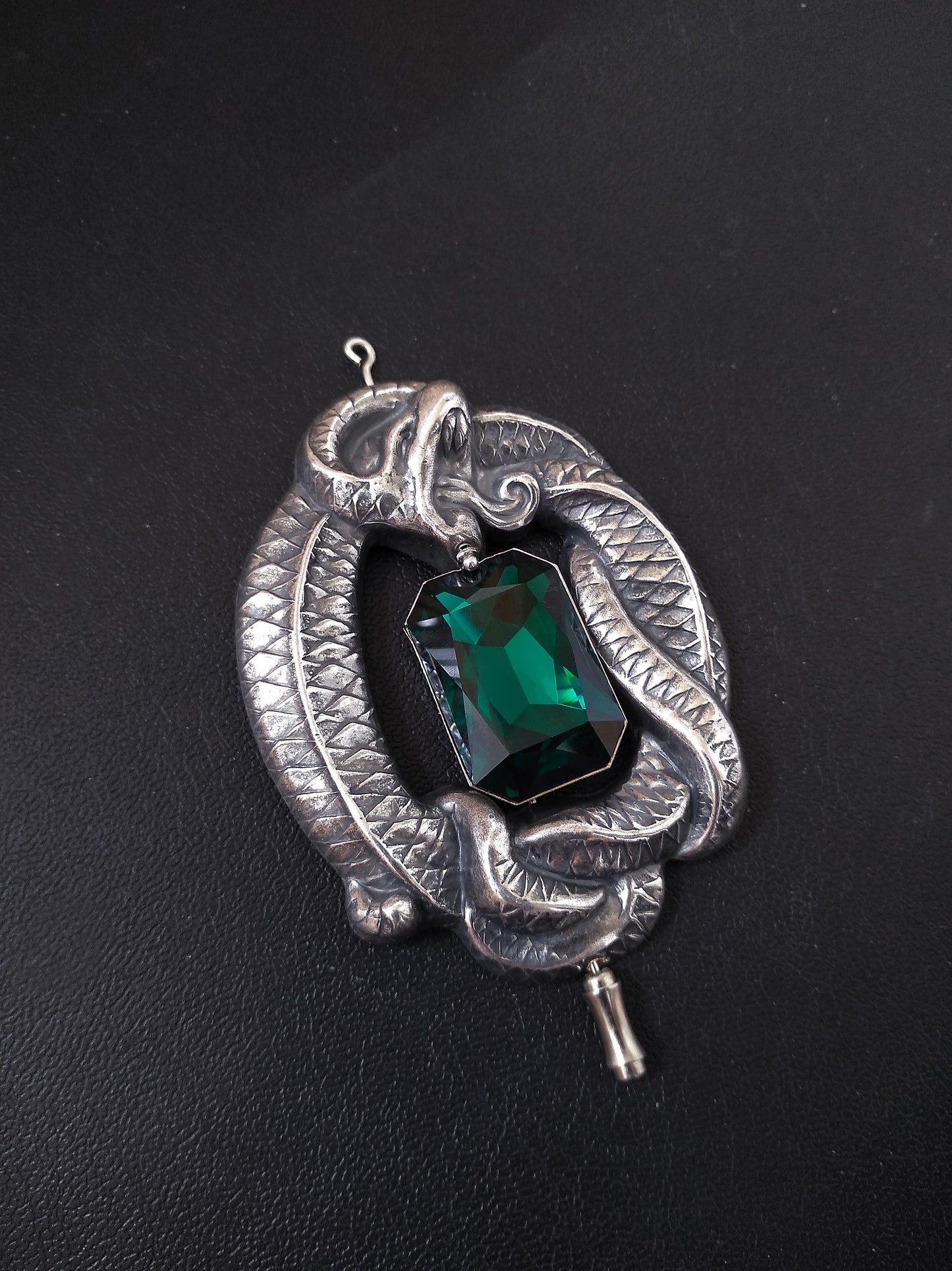 Silver Gothic brooch pin shaped as a large coiled snake with amazing details wrapped around a large Emerald Austrian crystal jewel in octagon shape.