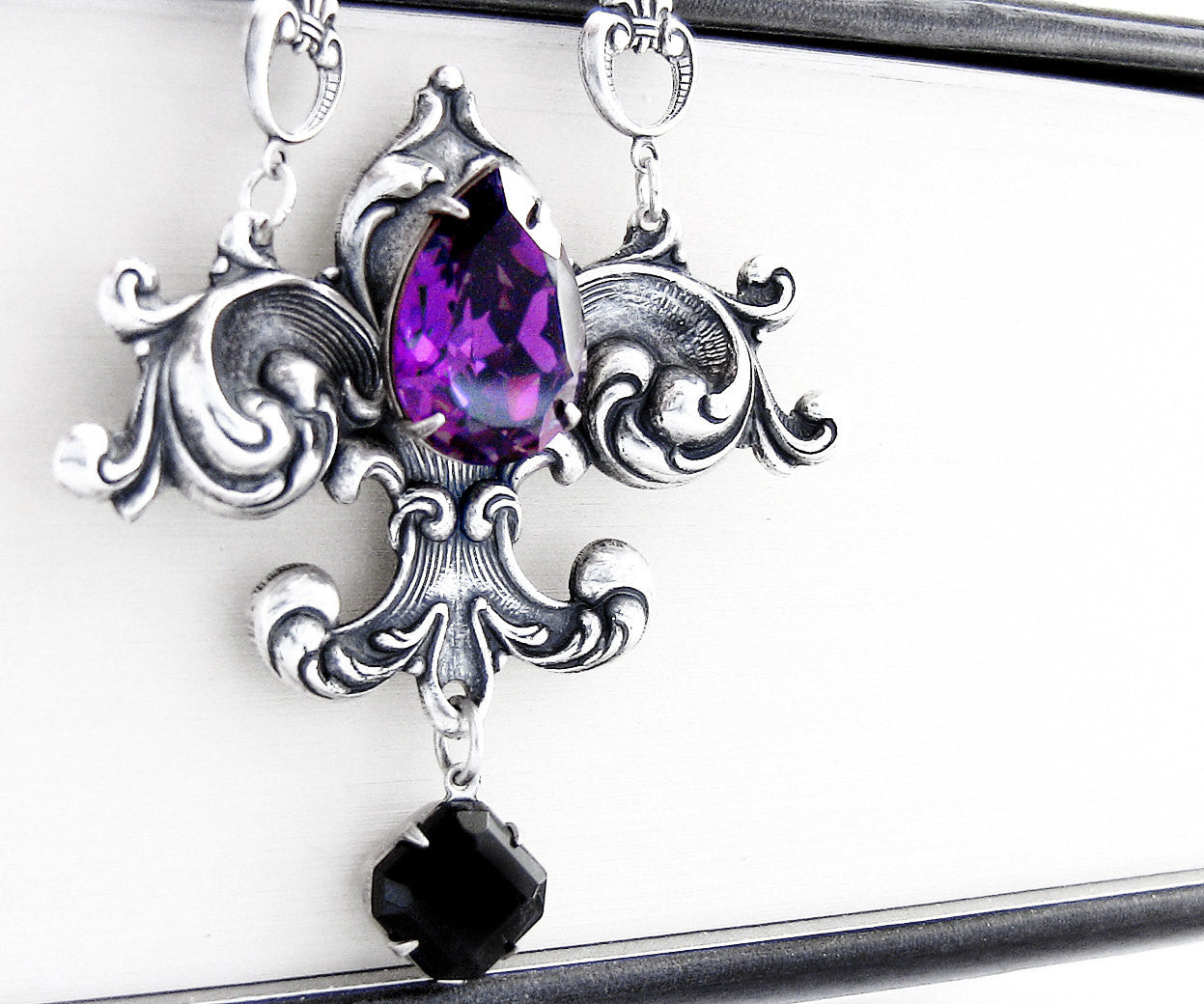 Victorian Gothic Fleur De Lys Necklace with a focal Purple Crystals and a smaller black one dangling below.
 - 1